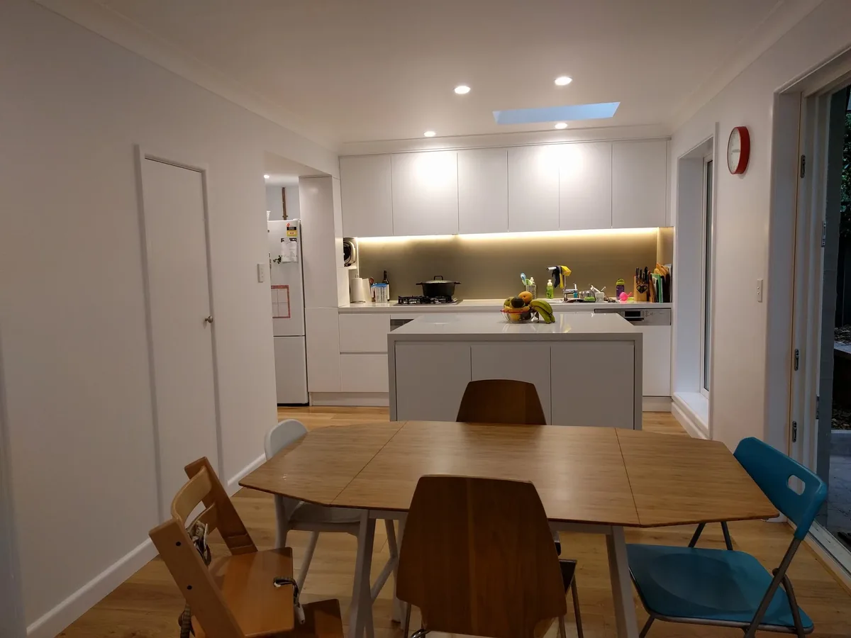 Completed kitchen and dining area with custom detailing and integrated lighting